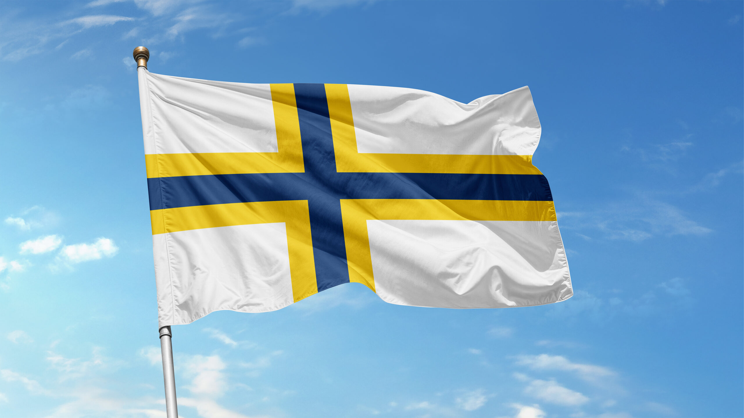 Sverigefinska flaggan mot en blå himmel med några mindre vita moln,